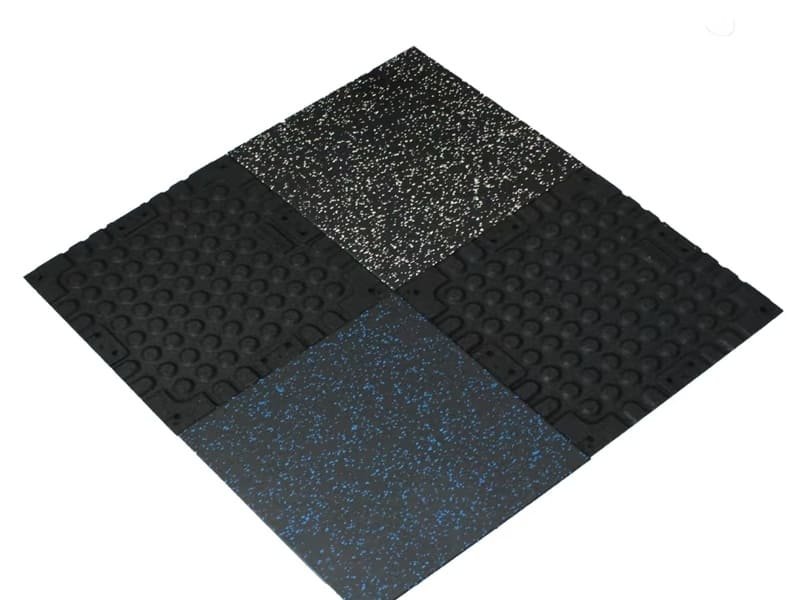 A well-lit commercial gym with thick black rubber floor tiles.